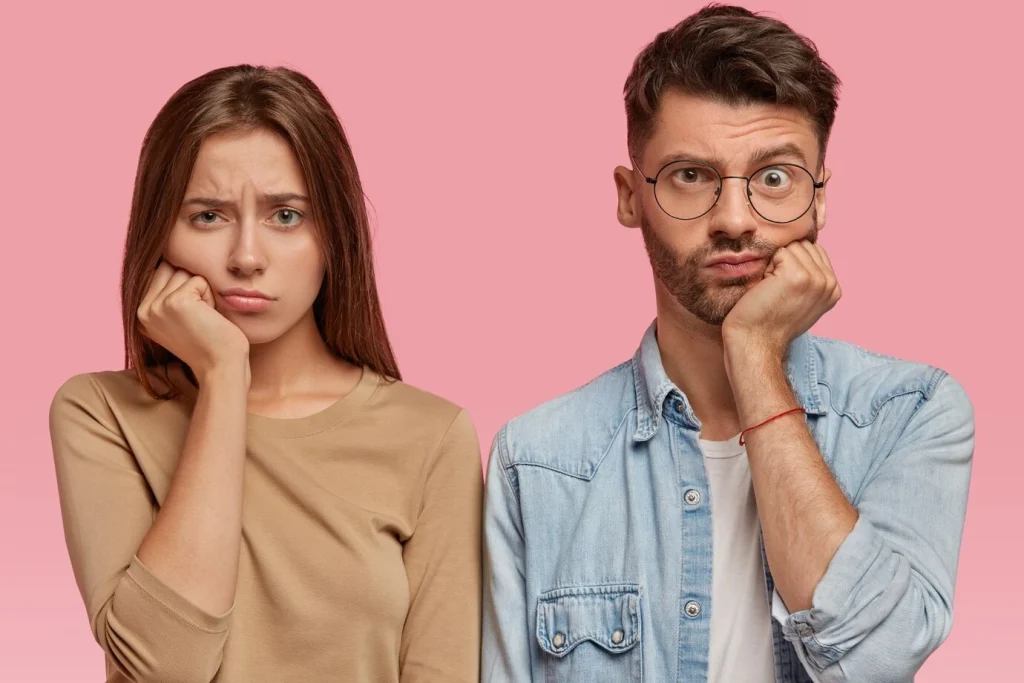 bored girl boy keep hand chin look with sadness directly feel dissatisfied wait something long time stand against pink wall people facial expressions concept 273609 29523